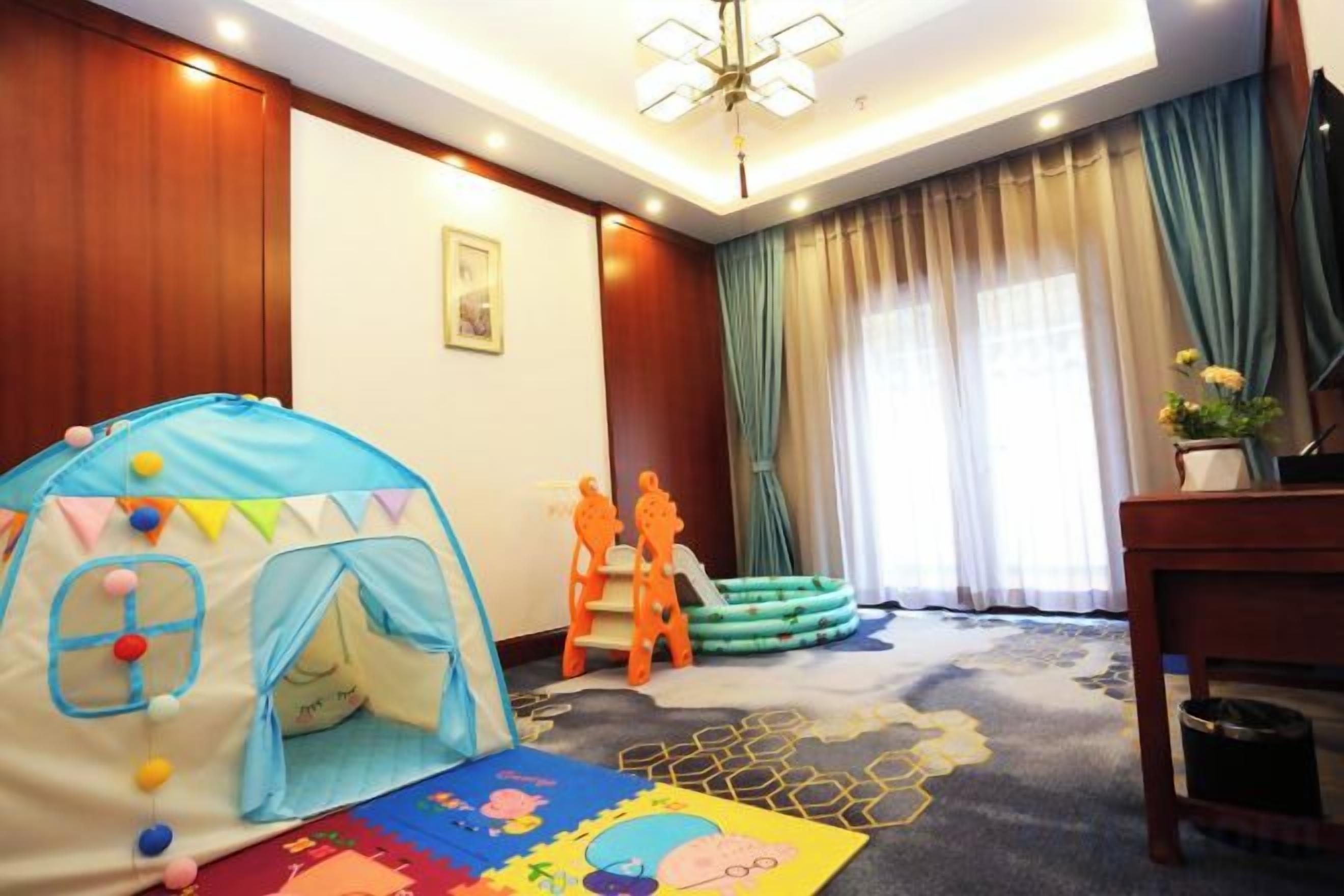 Una habitación con una tienda de juegos, un caballo de juguete y una alfombra colorida.