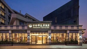 Un hotel con fachada moderna, grandes ventanales de vidrio y un cartel que indica que es el Grand Ogy Hotel.