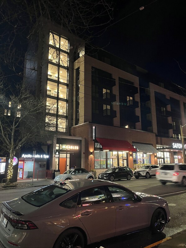 A multi-story building with various storefronts, including a nail salon and a pharmacy.