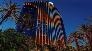 A tall, modern hotel with a distinctive vertical lighting design, surrounded by palm trees. - Masquerade Tower at Rio Hotel & Casino (Las Vegas)