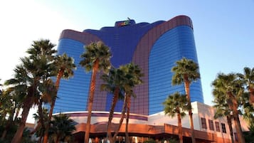 Un hotel moderno y grande con una fachada curva y un logotipo destacado en la parte superior.
