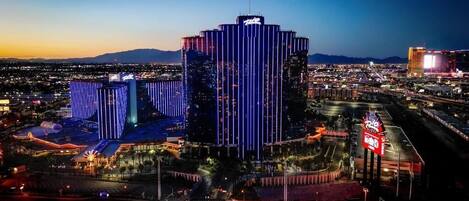 A high-rise hotel with vertical lighting, a casino, and a large sign with illuminated letters.
