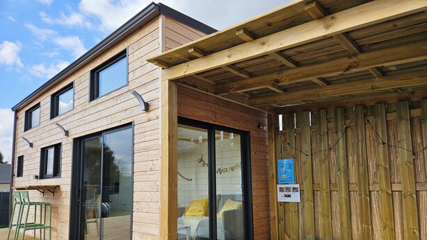 A wooden building with a glass door, a hot tub, and a wooden deck. - Tiny House with private Spa (Boigny-sur-Bionne)