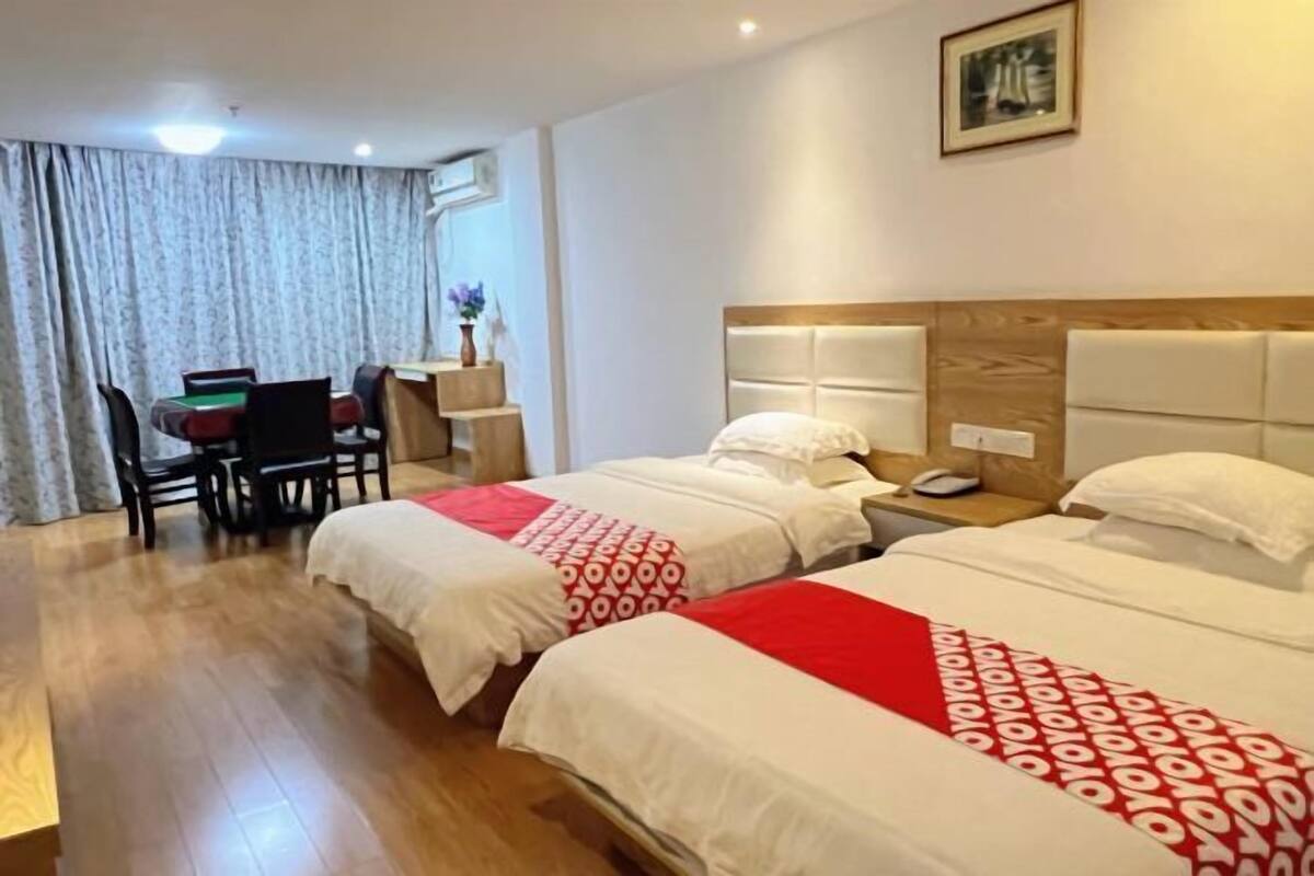 Een hotelkamer met twee bedden, een bureau en een stoel.