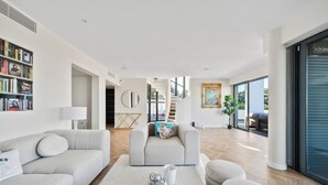 A modern living room with a grey sofa, a coffee table, and a bookshelf.
