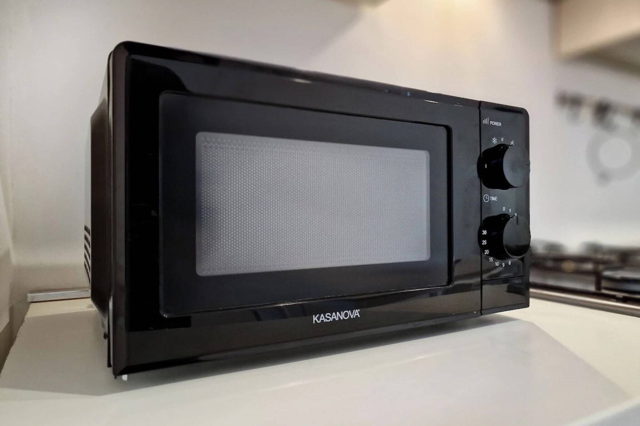 A Kasanova microwave oven with a digital display and control knobs.