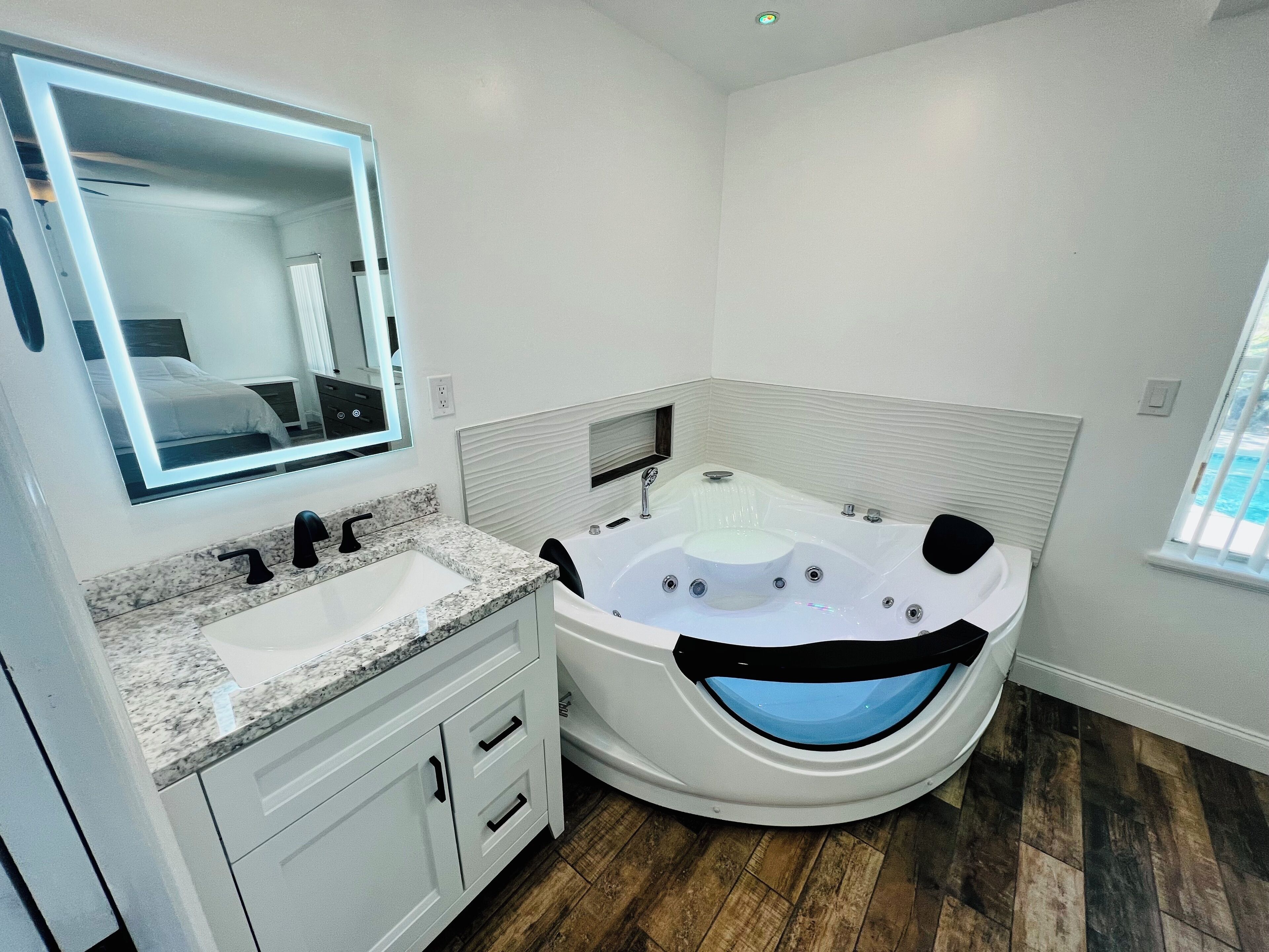 Une salle de bain moderne avec une grande baignoire, un meuble-lavabo et un miroir.