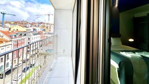 A balcony with a view of a cityscape, including buildings and construction cranes. - D. Carlos (Lisbon)