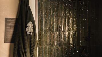 Una toalla con la inscripción 'TERRA' y 'Rain Room', un cartel con la descripción 'Rain Room', y una pared con textura.