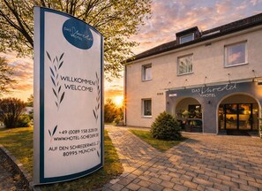 Et hotelskilt med en velkomstbesked og kontaktoplysninger.