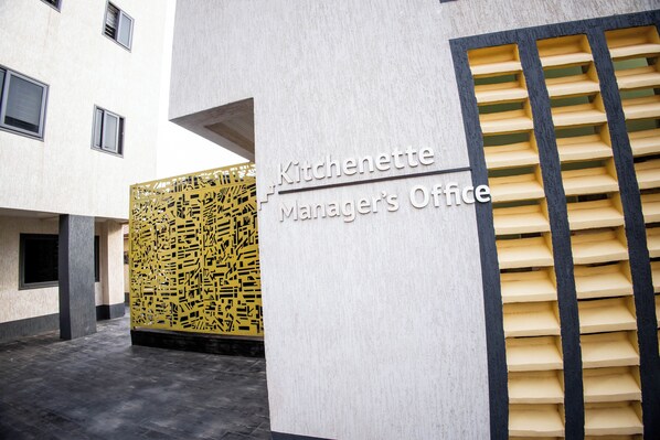 Entrada de um edifício com uma placa que diz 'Escritório do Gerente da Cozinha'.