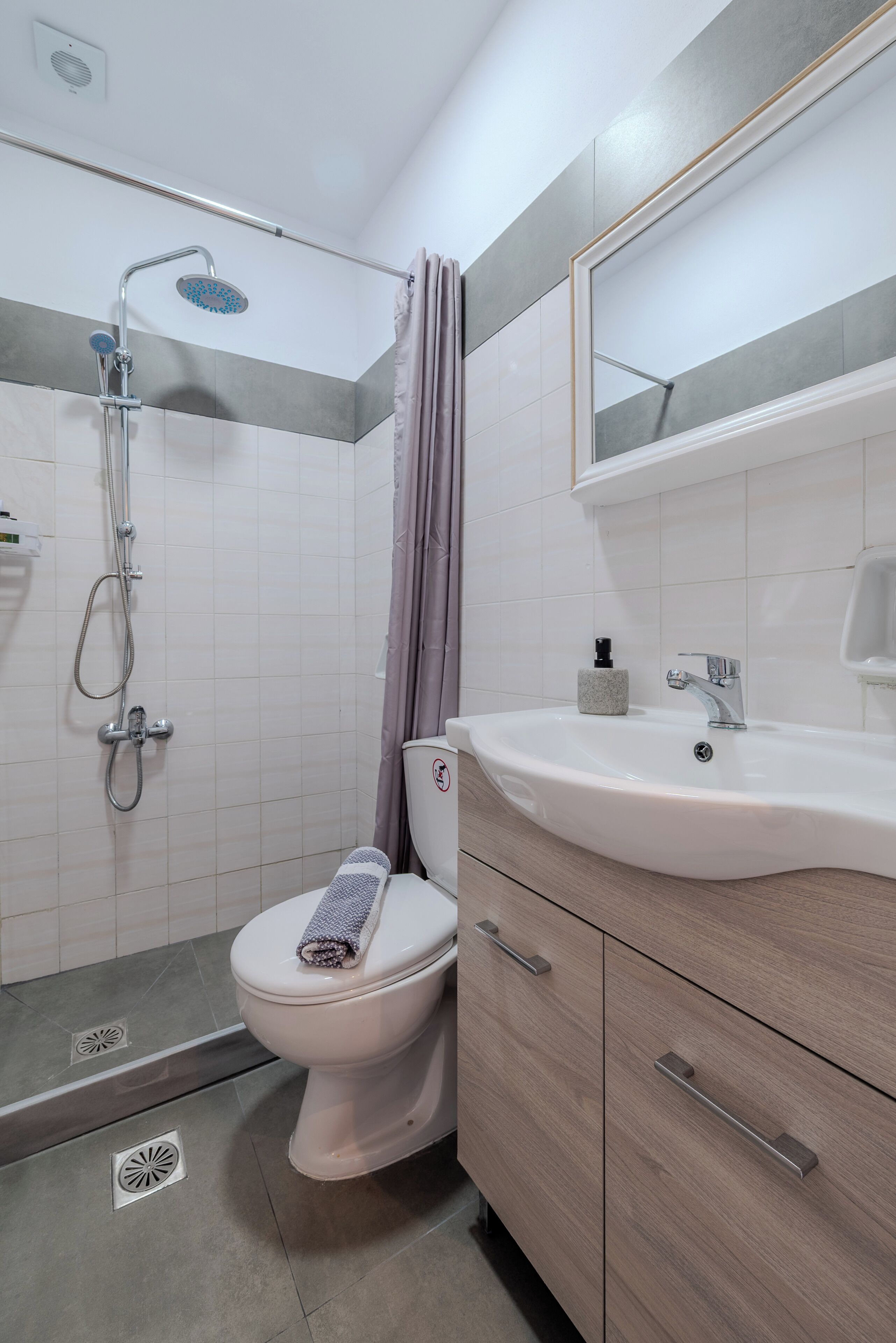 A bathroom with a shower, toilet, and sink.