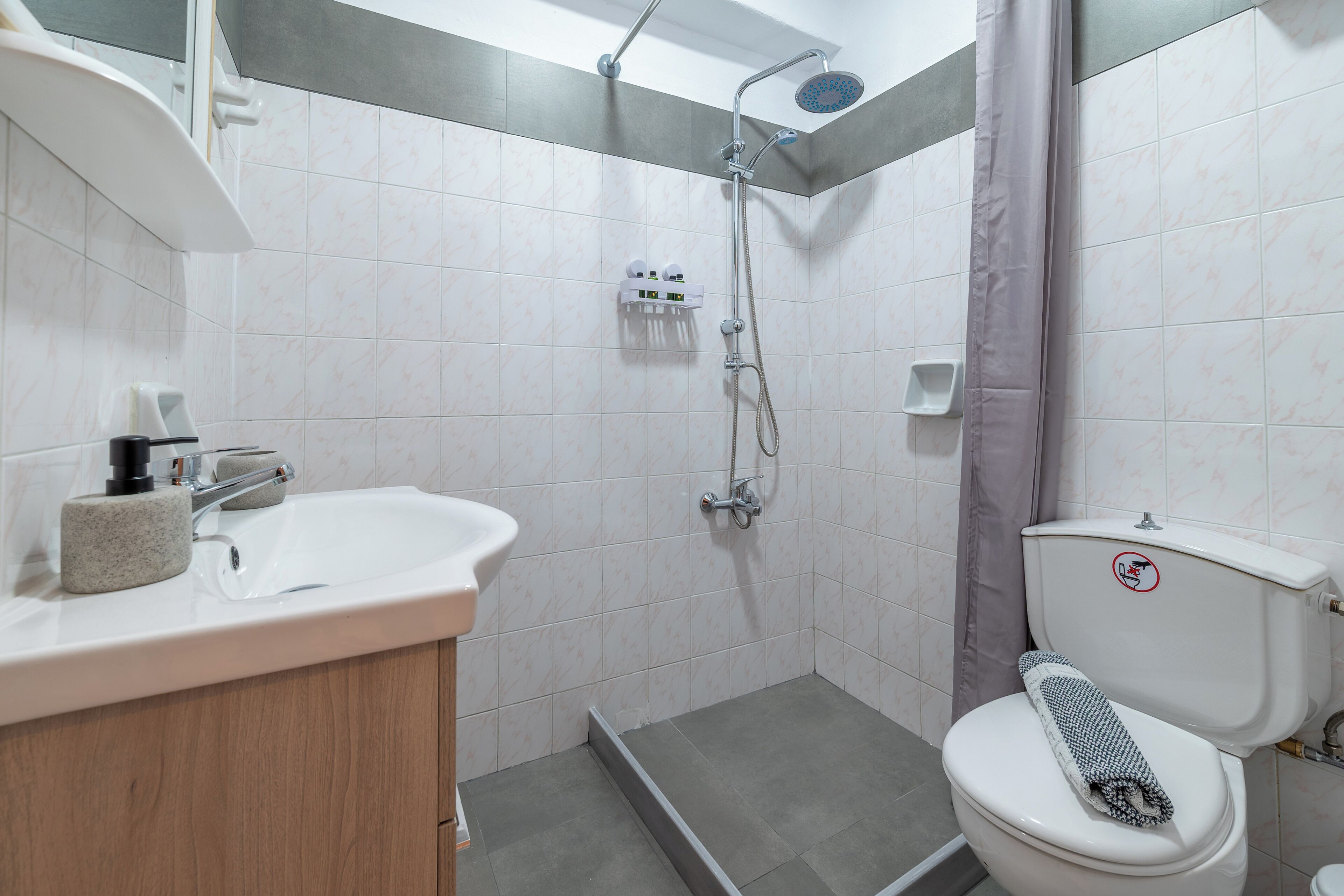 Une salle de bain équipée d’une douche, de toilettes, d’un lavabo et d’un porte-serviettes.