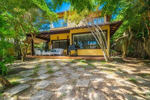 Una casa moderna con un patio, mobiliario exterior y un sendero de piedra.