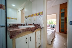 Une salle de bain avec un comptoir en marbre, un lavabo, un miroir et une serviette accrochée au mur.