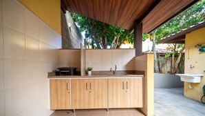 Una cocina con armarios de madera, una encimera, un fregadero y una planta en maceta.
