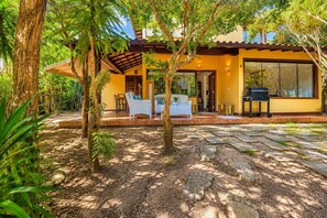 Une maison avec un patio, du mobilier d’extérieur et un barbecue.
