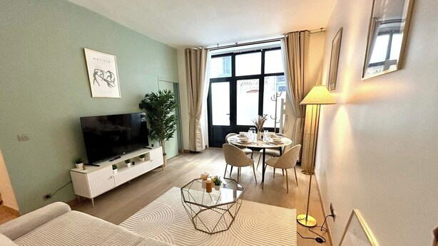 A modern living room with a sofa, TV, and dining area with a table and chairs. - Apartment - Arc de Triomphe - 4 people (Paris)