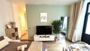 A modern living room with a sofa, a TV, a dining table set, a potted plant, and a framed artwork on the wall. - Apartment - Arc de Triomphe - 4 people (Paris)