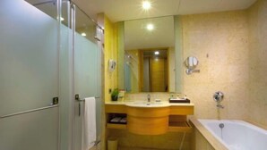 Une salle de bain avec une douche à parois de verre, un lavabo avec un miroir et une baignoire.