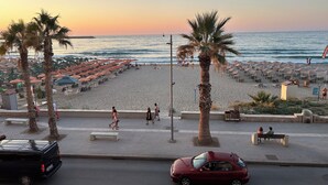 A beachside promenade with palm trees, beach umbrellas, and a view of the sea. - Beachfront Paradise (Rethymno)