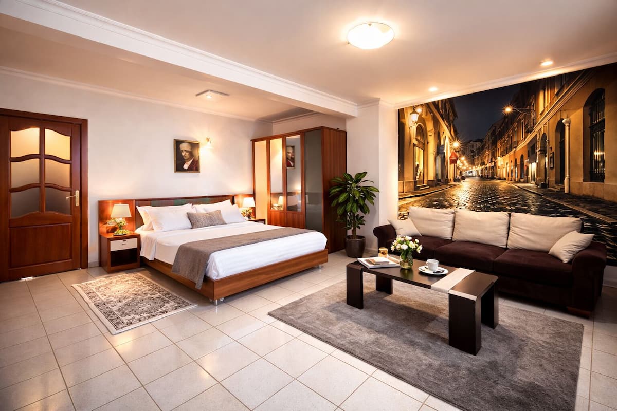 Ein modernes Hotelzimmer mit einem großen Bett, einer Couch, einem Couchtisch und Blick auf eine belebte Stadtstraße bei Nacht.