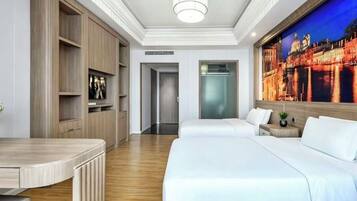 Ein Hotelzimmer mit Bett, Schreibtisch, Kleiderschrank und einem großen Fenster mit Blick auf die Stadt.