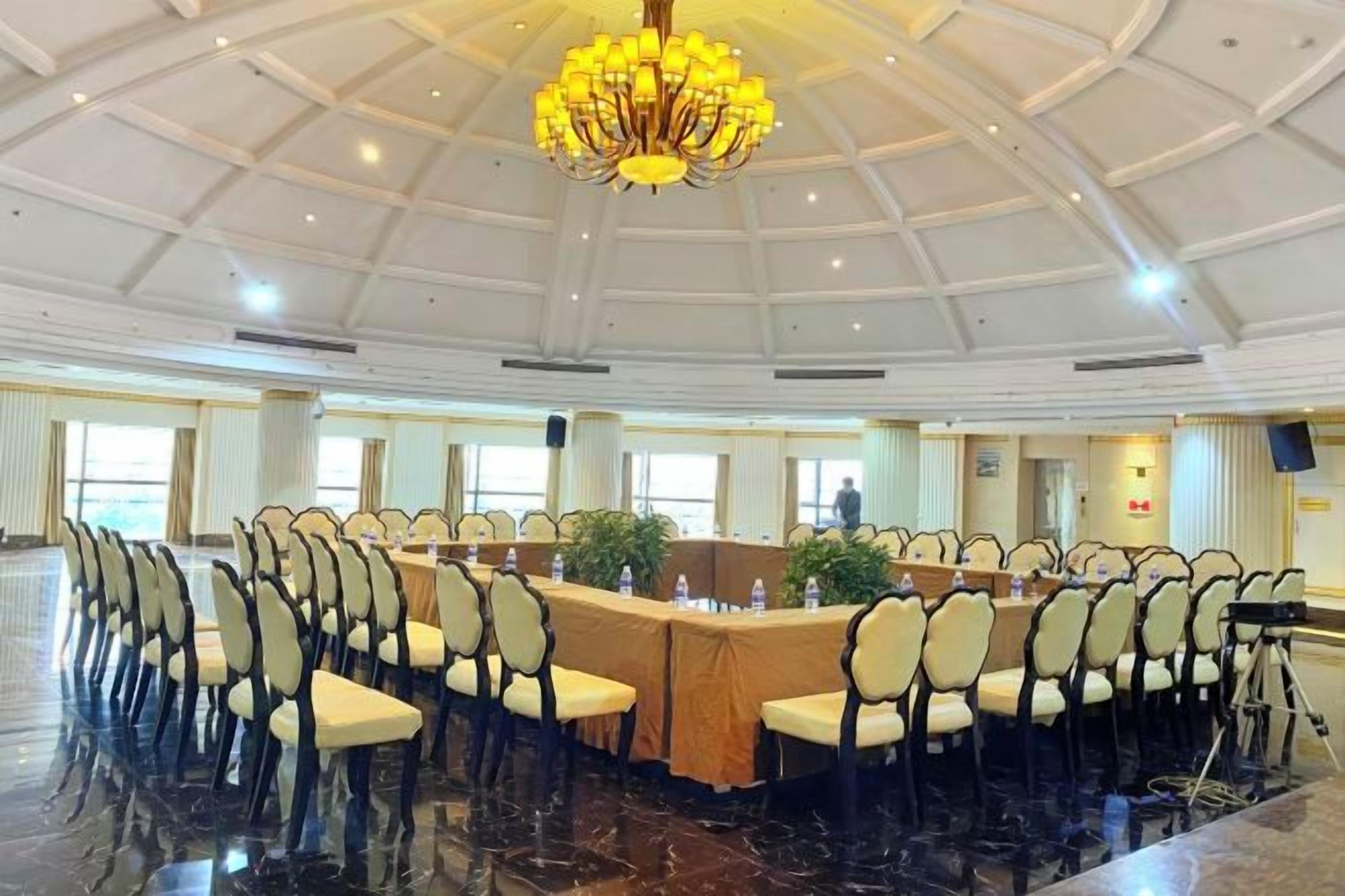 A conference room with a long table, chairs, and a chandelier.