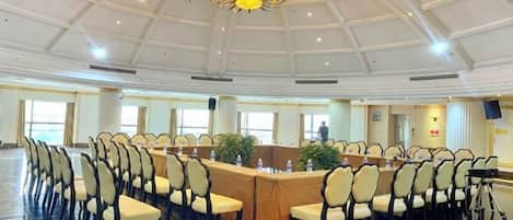 A conference room with a long table, chairs, and a chandelier.