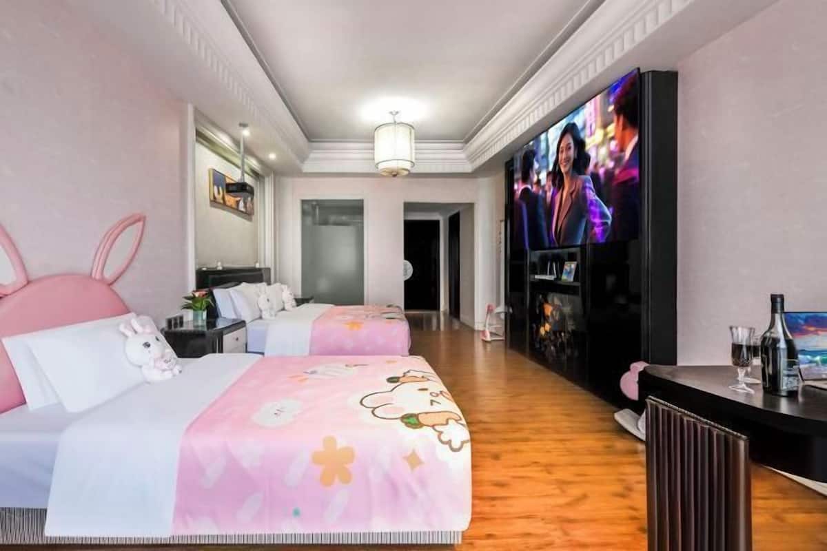 Een hotelkamer met twee bedden, een televisie, een minibar en een zichtbare badkamer op de achtergrond.