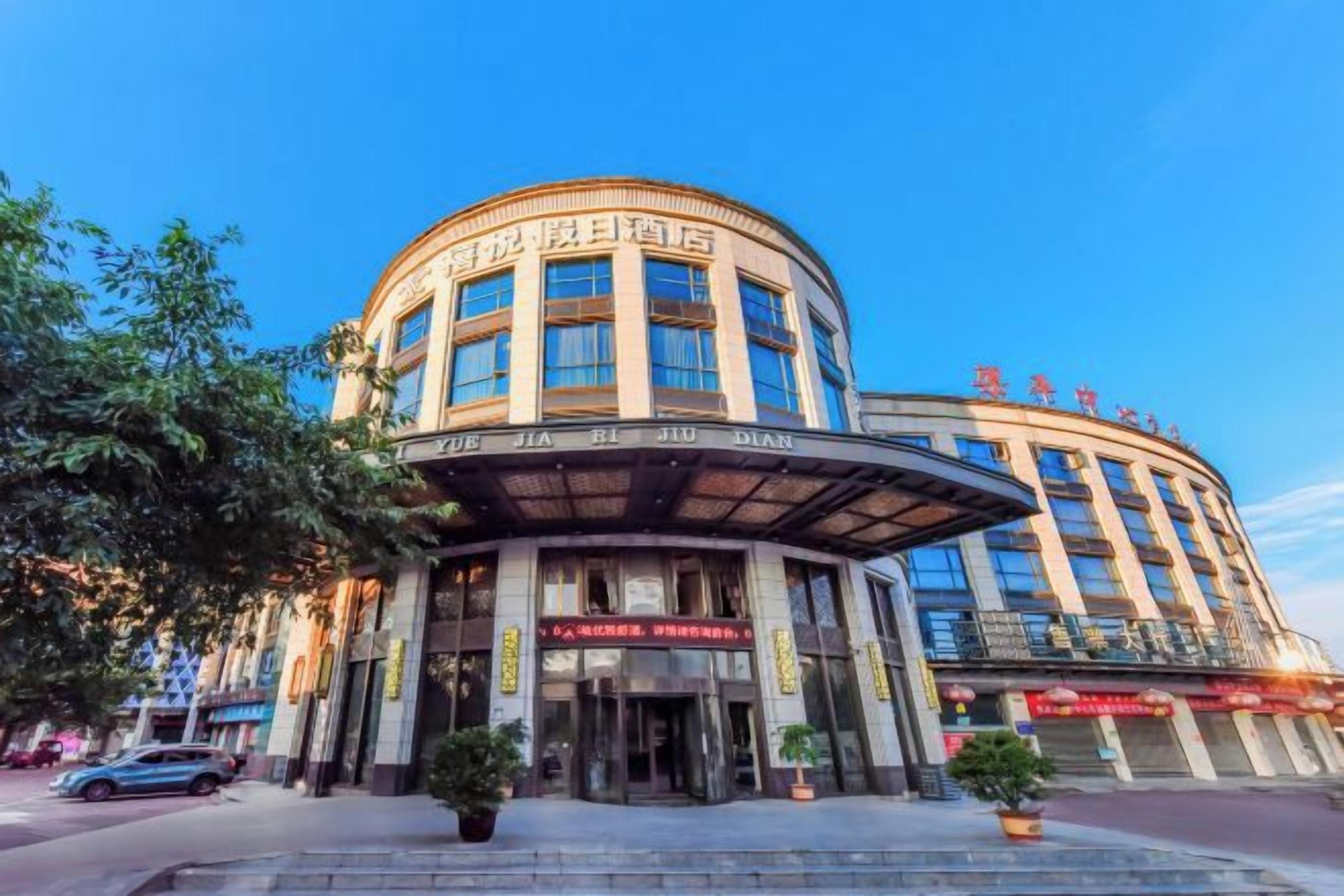 A multi-story hotel with a curved facade, large windows, and a prominent entrance.