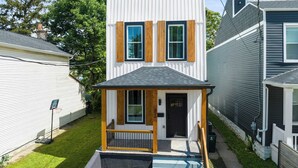 A two-story house with a small front porch and a visible front door. - Heights on Wayne by Blackhouse (Cincinnati)