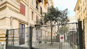 A gated entrance with a no parking sign, a tree, and a building with ornate architecture. - Goa Sea Apartment - Free Parking with Direct Access (Genova)