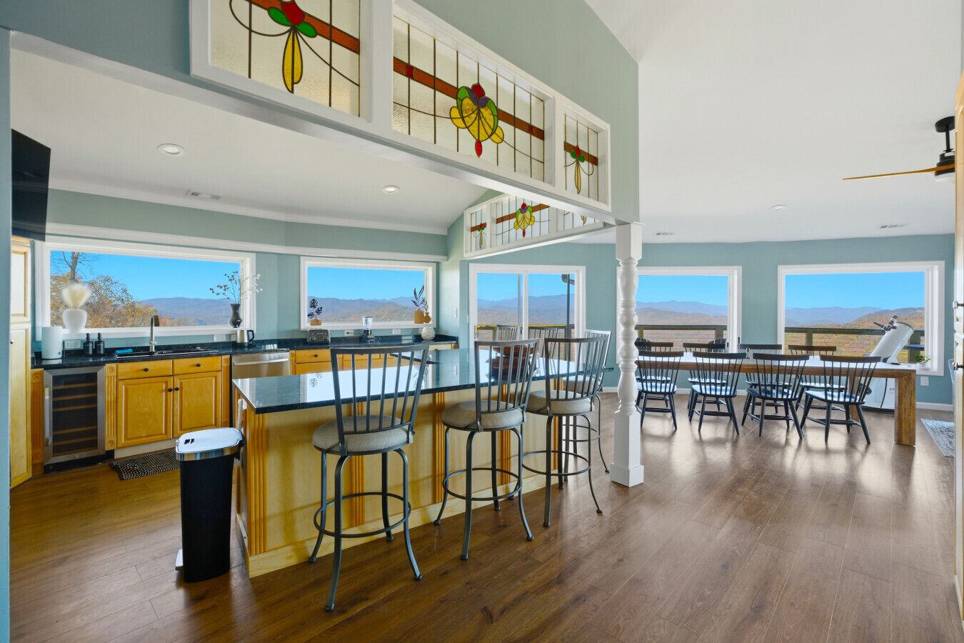 A spacious kitchen with a large island, wooden cabinets, and a view of the mountains.