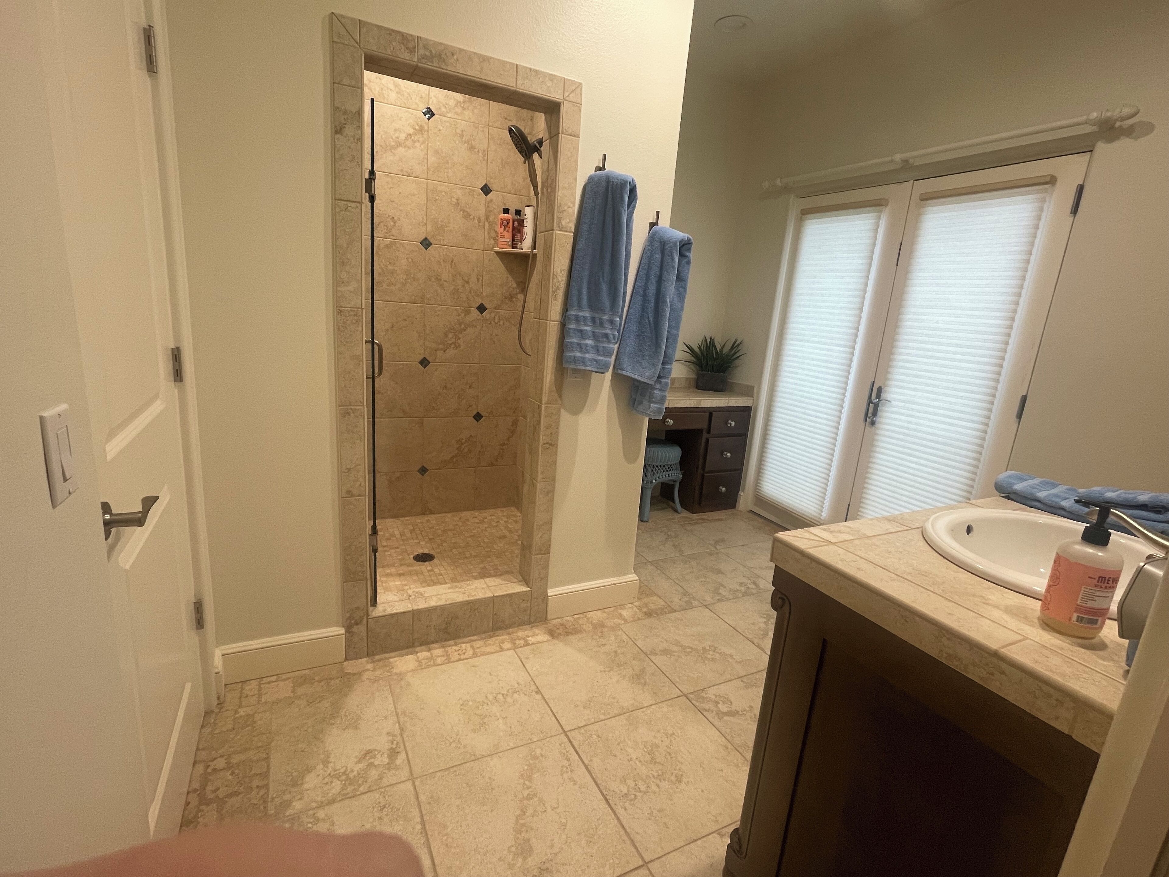 Une salle de bain avec une douche, un lavabo et un meuble-lavabo.