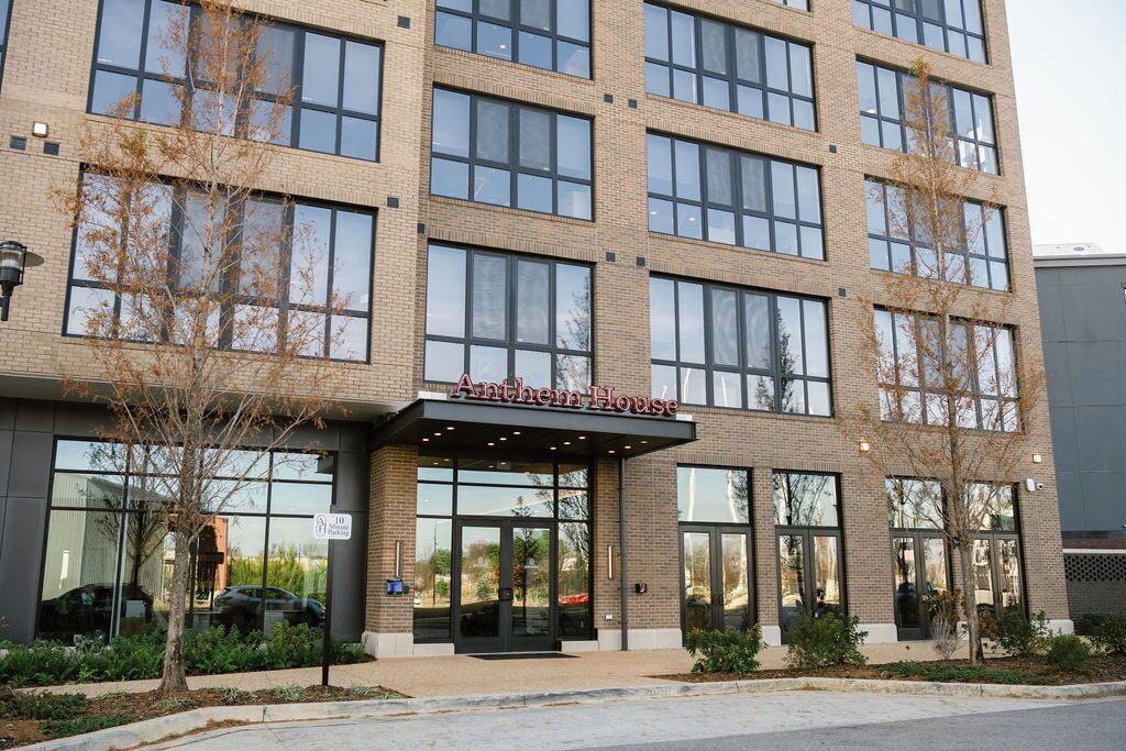 A multi-story building with a brick facade and large windows. The name "Anthem House" is displayed above the entrance.