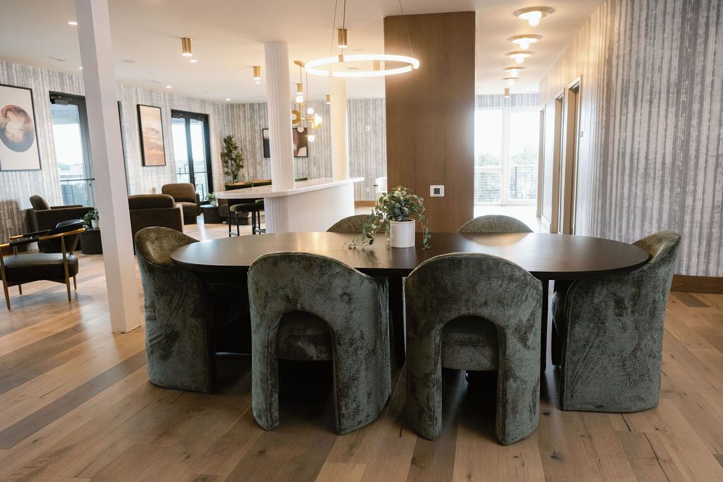Comedor moderno con una mesa redonda y seis sillas tapizadas.