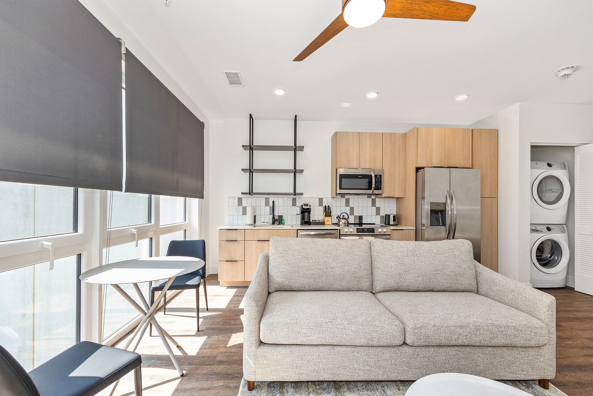 A modern kitchen with wooden cabinets, a stainless steel refrigerator, and a built-in microwave.