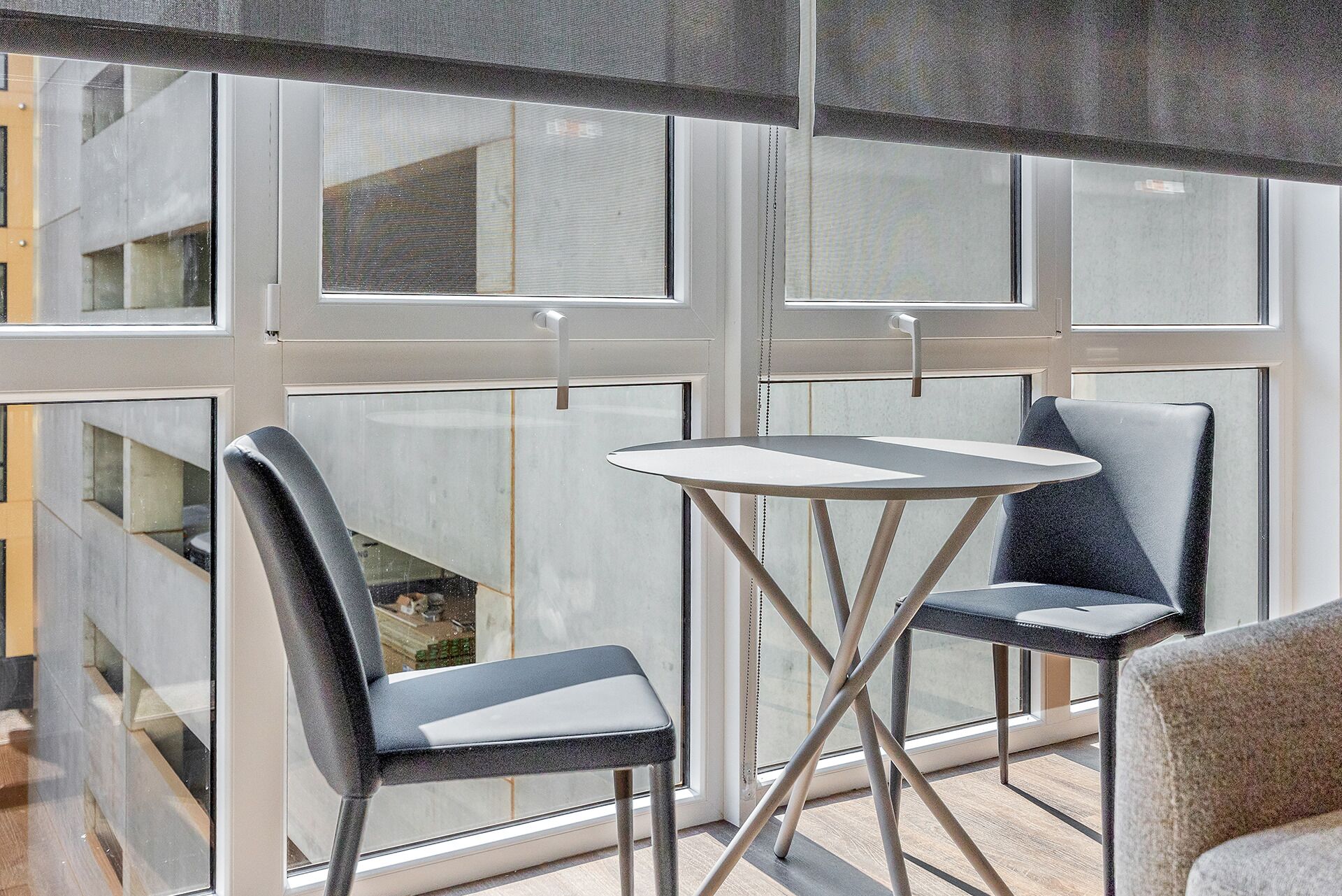 A modern room with a large window, two chairs, and a small table.