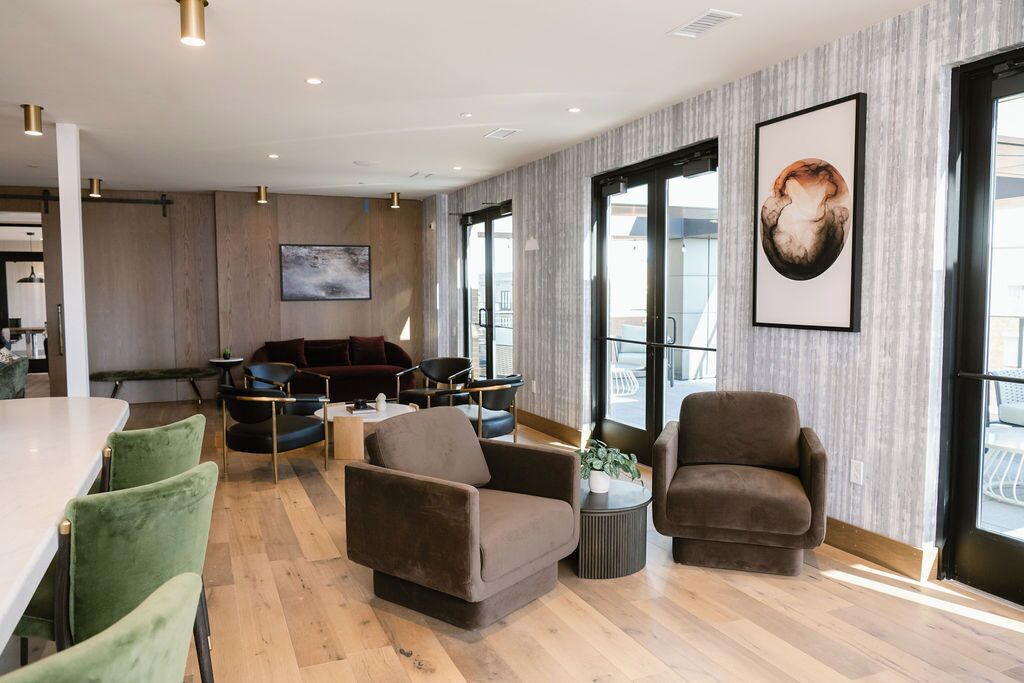 Un intérieur moderne comprenant un coin repas, un espace salon avec cheminée et de grandes fenêtres.