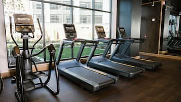 A gym with treadmills, ellipticals, and a rowing machine.