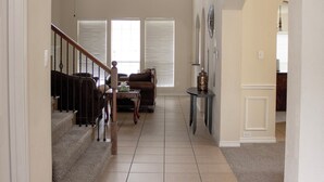 Un amplio espacio de estar con una escalera, un sofá y una mesita de centro.