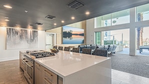 A modern kitchen with a large island, built-in appliances, and a view of a cityscape through large windows. - Near Mayo Clinic | King Bed | Heated Pool (Phoenix)