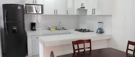 Fridge, microwave, coffee/tea maker, cookware/dishes/utensils