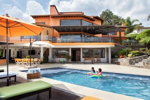 Alberca al aire libre y camastros 
