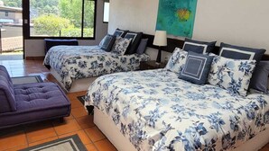 Une chambre avec deux lits, un canapé et une grande fenêtre.