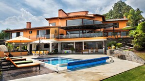 Une maison moderne à deux étages, dotée d’une piscine, d’un espace extérieur aménagé et d’un jardin bien entretenu.