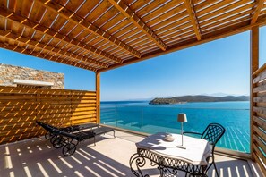 Ein Balkon mit einer Holz-Pergola, einer Steinmauer und Meerblick.