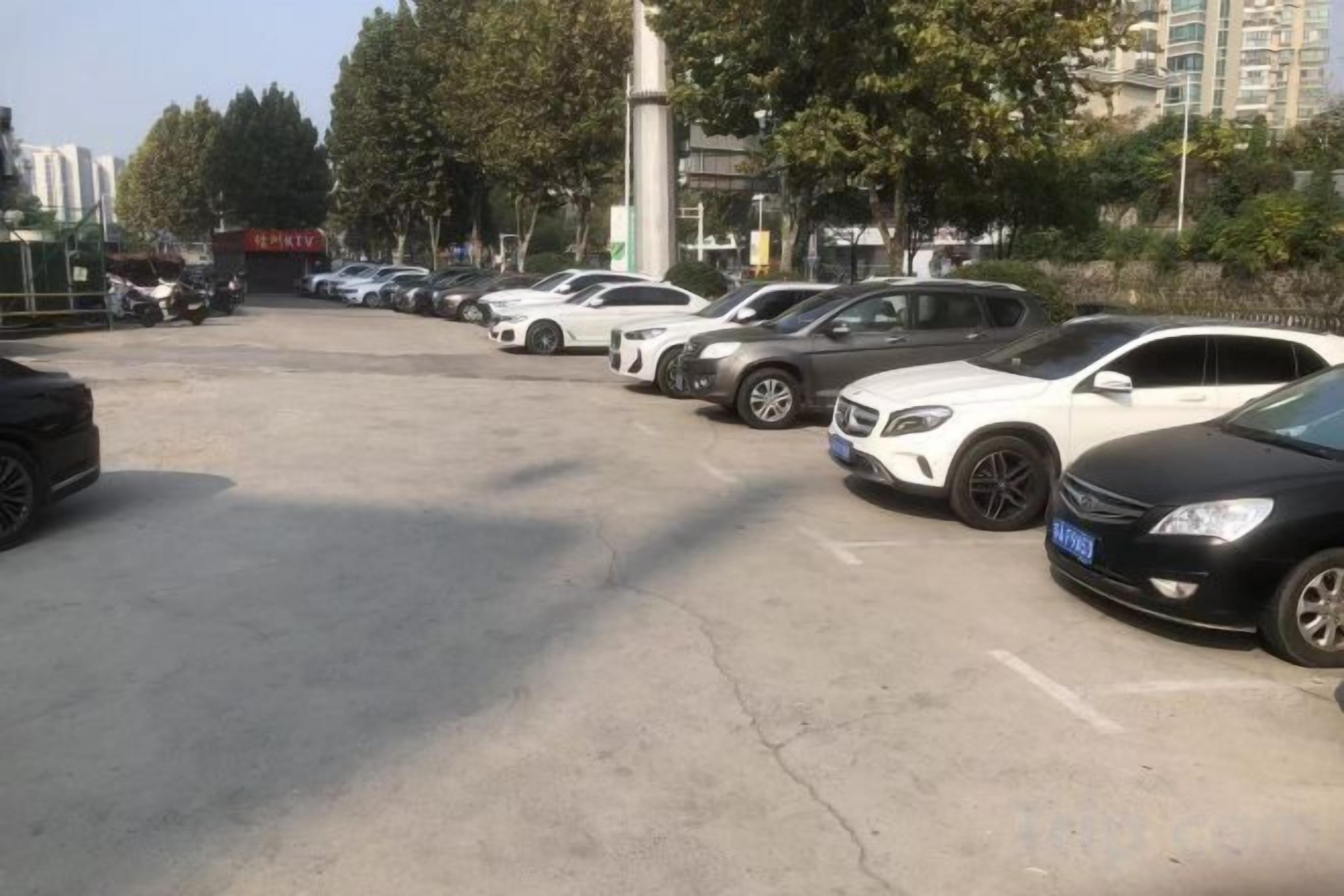 Un parcheggio con diverse auto parcheggiate in file.
