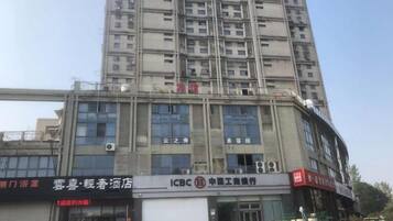 A multi-story building with several commercial establishments on the ground floor, including a bank and a hotel.